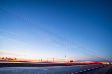 Fototapeta na wymiar wind turbines at sunset along highway morning commute