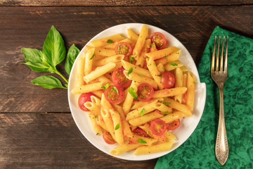 Penne pasta with tomato sauce and fresh basil leaves