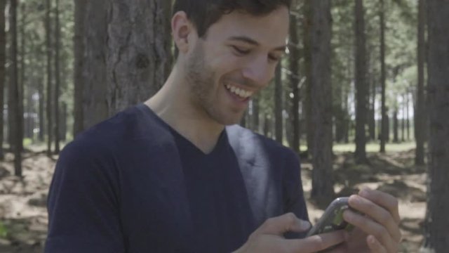 Man using smart phone in woods