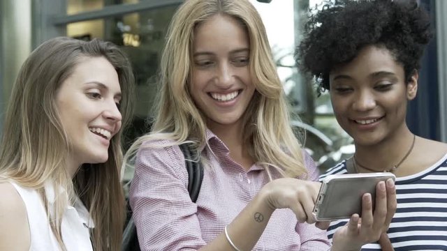 Girlfriends looking at smart phone together