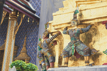 Demon Guardian/ Giant Statues stand around pagoda and hand to lift the base of the golden pagoda of thailand at wat phra kaew