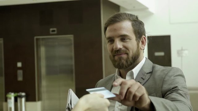 Businessman being handed hotel keycard