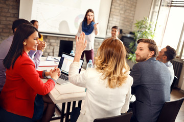 Speaker on business meeting gives word to young woman