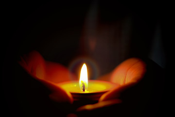 Prayer and hope concept of candle light in hands