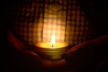 Prayer and hope concept of candle light in hands