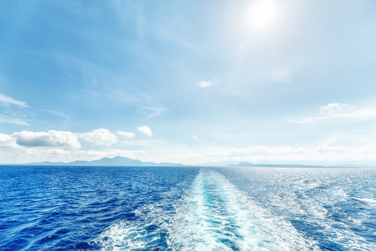 Trali print on water surface behind of cruise ship. Sunny day scenery.