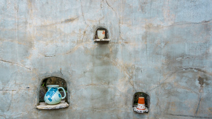 Pottery displayed on a rustic outdoor wall.