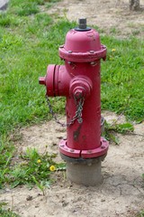 Fototapeta na wymiar The red fire hydrant in the grass on a close up view.