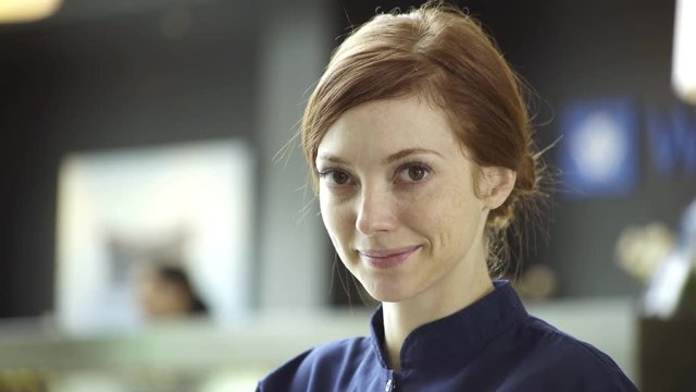 Woman looking down shyly and then smiling at camera