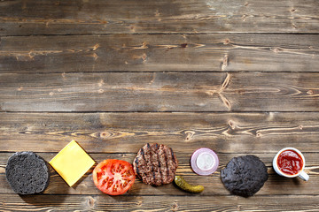 Dark restaurant menu, burger ingredients and copy space. black bun for Burgers. top view.