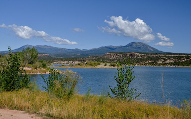 Fototapeta na wymiar Recapture Reservoir with white clouds over Abajo Mountains in the background Blanding, San Juan County, Utah, United States 