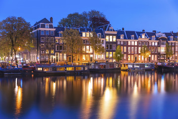 Fototapeta premium Evening town Amsterdam in Netherlands on bank river canal Amstel