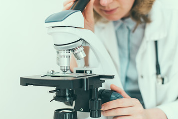 Scientist using microscope in laboratory.