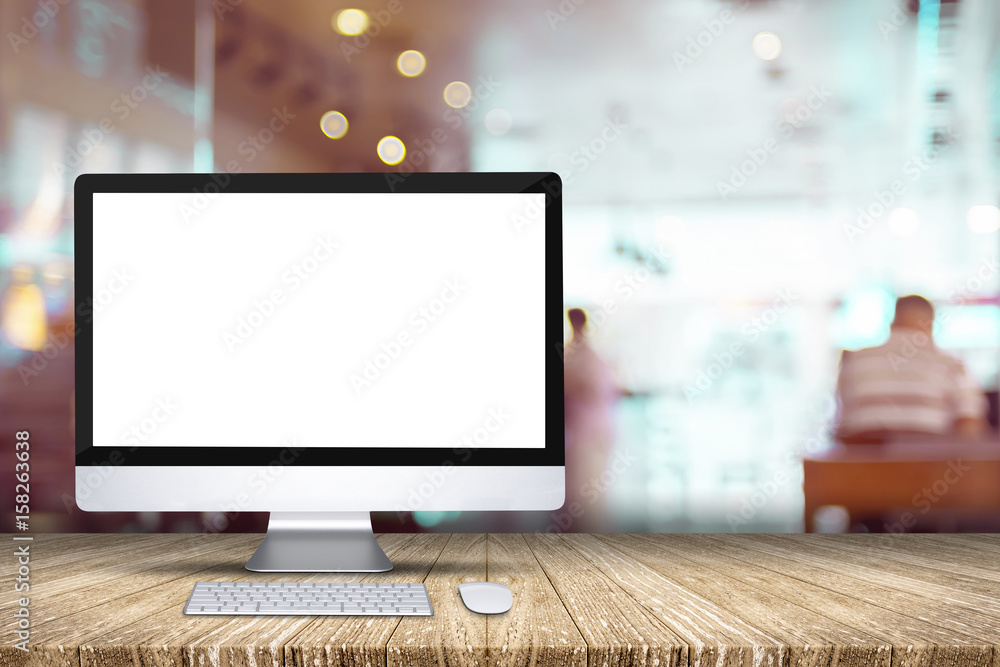 Poster blank screen desktop computer on plank wooden table top with blur restaurant bokeh background,mock u