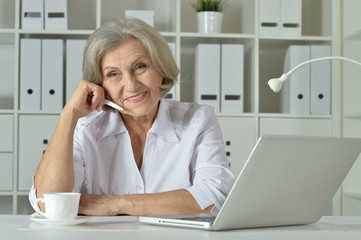 Old business woman with laptop working 