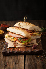 Delicious grilled hot dog with sausage and bacon, ketchup and mustard