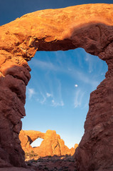 View of North Window through the Turret Arch with Moon rising in Arches Naional Park.