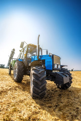 Obraz premium Modern tractor in the field on a sunny autumn day.