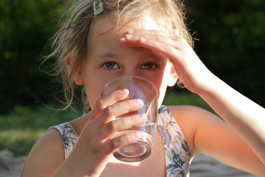 Portrait blondes Mädchen trinkt Wasser aus Glas
