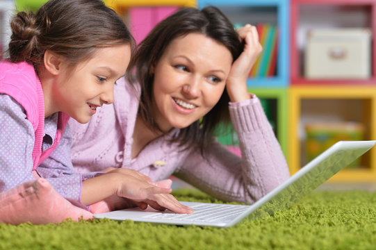 Mother with her daughter enjoying a laptop