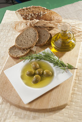 Olives with olive oil and bread with rosemary 