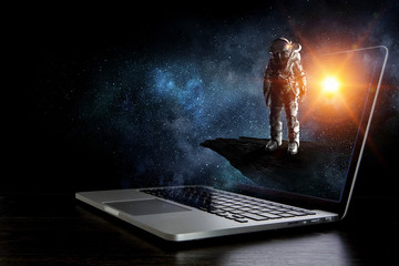 Space explorer and laptop. Mixed media