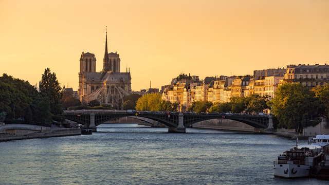 Notre Dame de Paris Cathedral, Ile Saint Louis, the Sully Bridge, and the Seine River at sunset in Summer. 4th Arrondissement of Paris. France