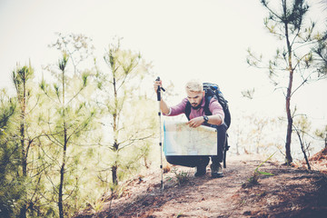 Portrait of adventure young man hiking with map on mountain
