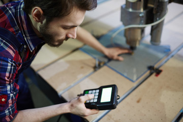 Master with electronic machine standing by workplace