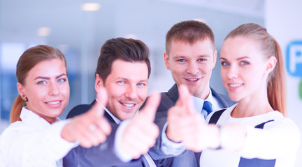 Obraz premium Happy business team showing thumbs up in office