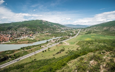 Motorway in the Georgian valley. Travelling and tourism in Georgia. Skyline of Caucasian landscape....