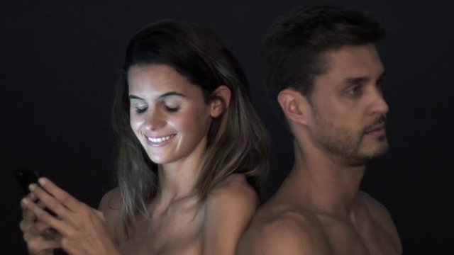 Woman absorbed in smartphone and ignoring boyfriend