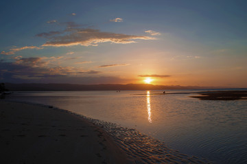 Orange sunset on the beach. Sun reflection on the sea