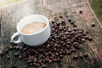 Hot cub of coffee and bean on wooden background