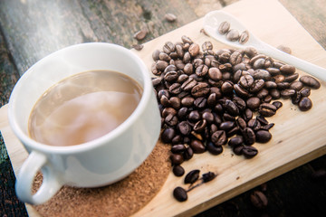 Hot cub of coffee and bean on wooden background