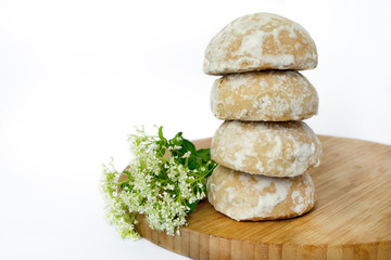 Simple white cookies on a wooden board and flower