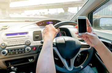Naklejka premium man using mobile phone while driving a car on expressway