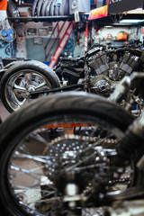 Fototapeta premium Row of disassembled motorcycles set for tuning up and customizing in mechanics workshop