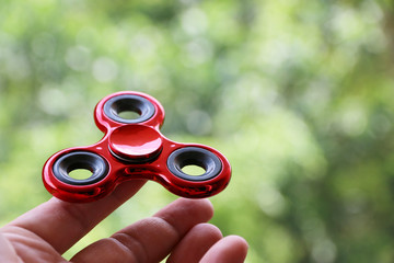Man playing with Red fidget spinners outdoors popular toy