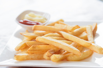 French fries in a bowl on a wooden background