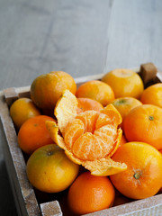Fresh tangerines in an old box . On wooden background. Free space for text .