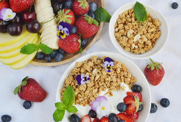 Yogurt with granola and fruits, blueberries, strawberries, cherry, apple, banana, healthy breakfast