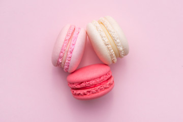 Fototapeta premium Tasty pink cake macaron or macaroon on pink background from above