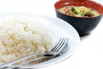 Rice with couple of spoon and fork on dish with mushroom curry soup