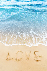 Love word written on the sand of the beach.