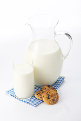 Pitcher and glass with some milk and cookies