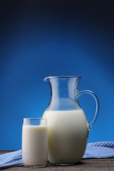 Jar and glass with some milk on blue