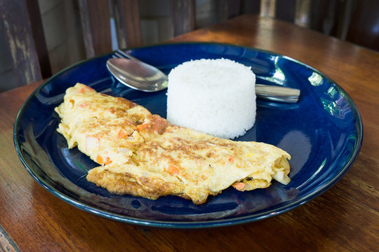 omelet and rice in dish at rustic restaurant , it's popular traditional Thai style food