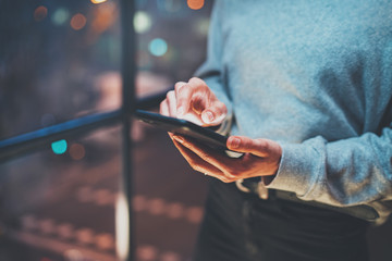 Closeup view of woman holding modern mobile phone in hands.Girl pointing fingers on empty touch...
