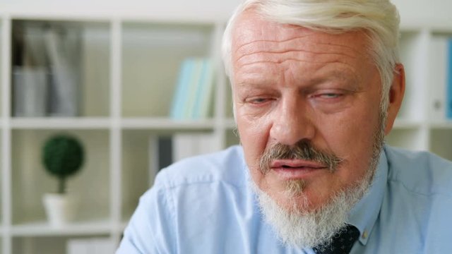 Portrait of handsome caucasian midle aged concentrated man seriously looking on the camera at office background. Indoor.